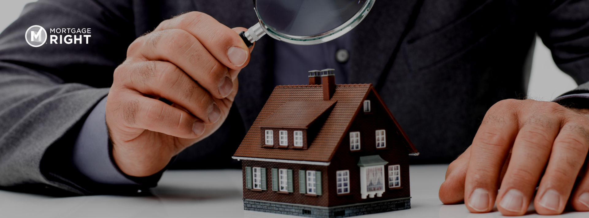 small toy home being looked at under a magnifying glass.